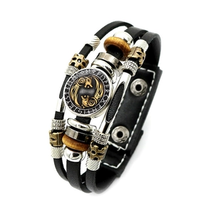 Macro shot of Viking multilayer leather bracelet with runes and golden wolf charm