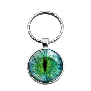 Vue macro détaillée du pendentif en verre œil de dragon sur un porte-clés en métal argenté