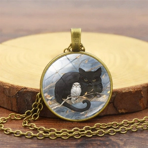 Détail du pendentif en bronze avec illustration de chat noir sur surface en bois