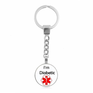 Macro detail of silver medical alert keychain with I'm Diabetic text and red star of life