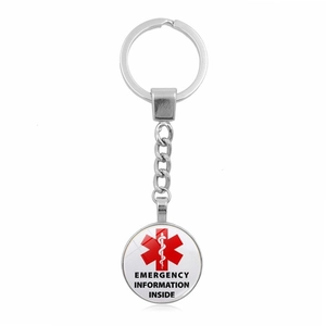 Close-up of the medical Star of Life emblem and emergency info text on a silver keychain