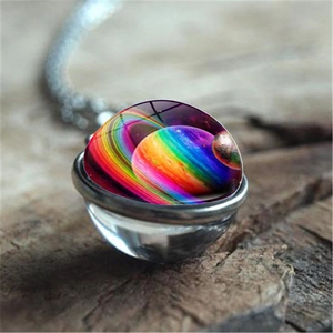 Vue macro d'un pendentif en verre nébuleuse avec chaîne argentée sur une surface bois