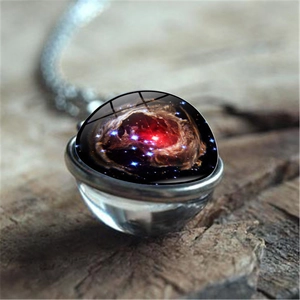 Détail macro d'un pendentif en verre nébuleuse galaxie sur chaîne en argent antique