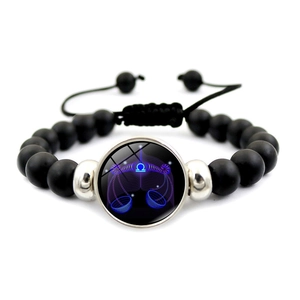 Detail of adjustable black matte Libra constellation beaded bracelet with glowing charm
