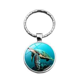 Détail d'un porte-clés en métal argenté avec un pendentif réaliste de tortue de mer bleue