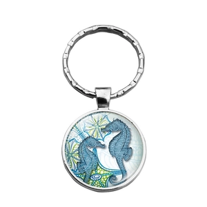 Détail du porte-clés hippocampe argenté avec motif océan bleu sous dôme de verre