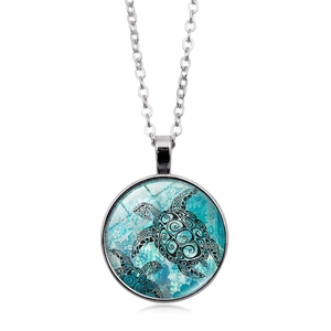 Collana con ciondolo a tartaruga marina in vetro e catena argento su sfondo bianco