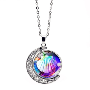 Detalle del colgante de luna creciente con patrón de concha colorida y cadena plateada