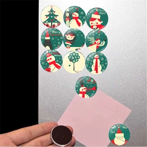 Makroansicht von Weihnachts-Kühlschrankmagneten aus Glas auf gebürstetem Metall
