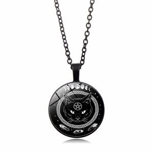 Macro detail of gothic black cat glass pendant with pentagram and moon phases motifs