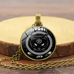 Detailed macro view of the black cat and pentagram bronze pendant on a wooden background
