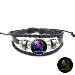 Détail du charm Capricorne lumineux sur bracelet en cuir tressé avec effet fluorescent