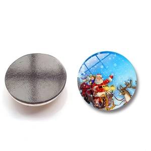 Close-up of circular Christmas fridge magnet showing glass dome and magnetic back