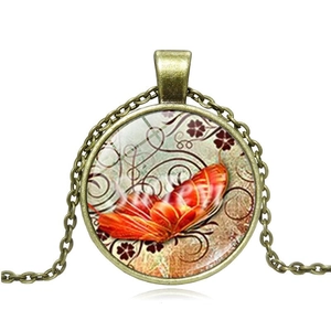 Close-up of vintage bronze butterfly glass cabochon pendant necklace on white background