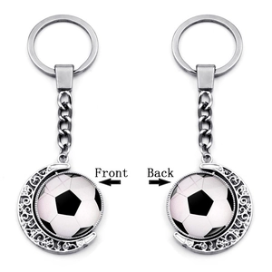 Detailed view of rotating football pendant with moon crescent design on silver keychain