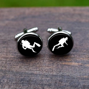 Classic silver scuba diver cufflinks featuring white silhouettes on a black background