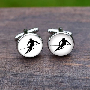 Polished silver cufflinks with black skiing silhouette on white background set on wood