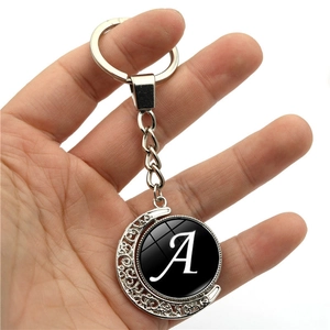 Handheld silver alloy moon keychain with a double-sided rotating letter A glass pendant