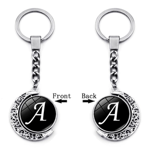 Close-up of double-sided rotating moon keychain with letter A on a white background