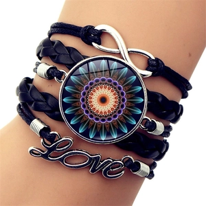 Detail of multi-layer leather bracelet with infinity symbol and mandala glass charm