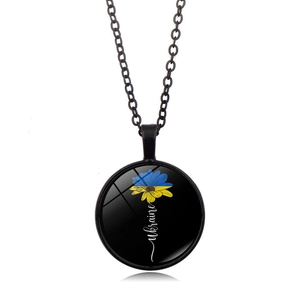 Dettaglio di girasole e scritta Ukraine sotto cupola di vetro su collana rotonda