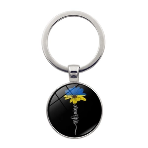 Detailed macro view of Ukraine sunflower charm with silver metal key ring and keyring