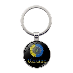 Detailed view of round glass keychain featuring Ukraine sunflower design and trident emblem