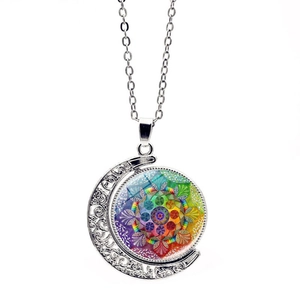 Détail du pendentif lune rotatif double face avec motifs mandala colorés sur chaîne argentée