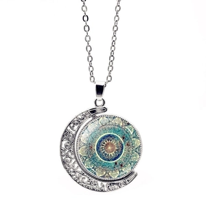 Vue détaillée d'un pendentif lune rotatif double face avec des motifs de fleurs mandala