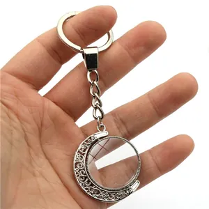 Silver rotating moon keychain with a customizable round disk pendant on a white background