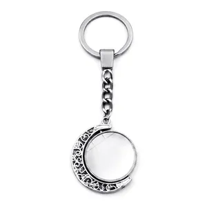 Customizable rotating silver moon keychain with a round metal pendant and hollow design