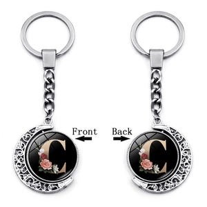 Detailed front and back view of silver moon-shaped rotating keychain with letter C