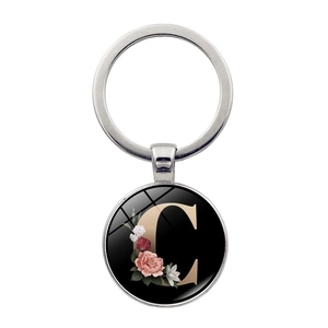 Macro detail of alphabet C keychain with colorful floral patterns and silver alloy finish