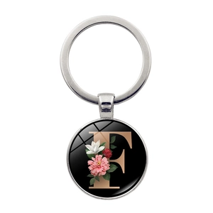 Detailed close-up of a silver letter F keychain with vintage floral rose design