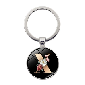 Silver metal keychain with letter X and floral pattern on a black round pendant