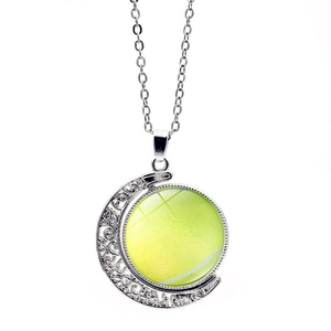 Gros plan du pendentif croissant de lune argenté avec un charme de tennis rotatif