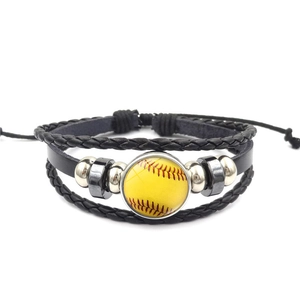 Detail van de gelaagde leren armband met verstelbare koorden en softball-bedel