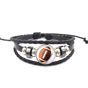 Detail van de meerlaagse lederen armband met football-bedeltje en verstelbaar koord