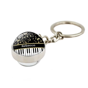 Detail of music theme keychain with piano keys and musical notes in a glass dome