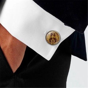 French shirt cufflinks with golden phoenix emblem on dark red glass dome surface