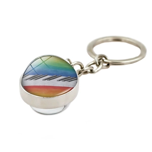 Detailed close-up of crystal glass keychain with piano keys and rainbow motif design