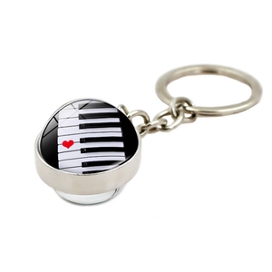 Macro detail of piano keys pendant with a red heart on polished silver metal keychain