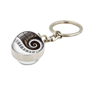Detailed side view of music piano key and golden note patterns inside a glass dome keychain