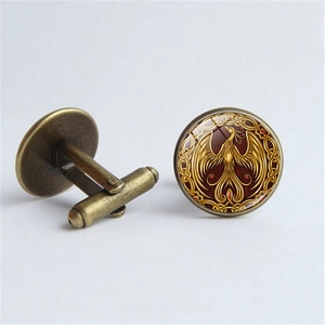 Detail of vintage bronze cufflinks with golden phoenix pattern under round glass dome