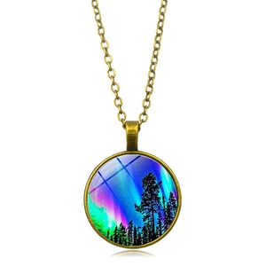 Macro view of bronze pendant featuring northern lights forest art under glass dome