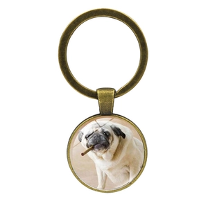 Detailed close-up of a bronze pug keychain with glass cabochon and cigar puppy design