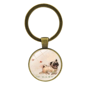 Detail of vintage bronze pug puppy keychain with artistic glass pendant on white background