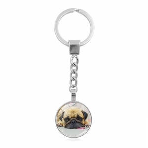 Macro shot of silver metal keychain with cute pug dog photo glass dome pendant charm