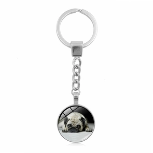 Detail of silver pug keychain with round glass cabochon featuring a cute pug portrait