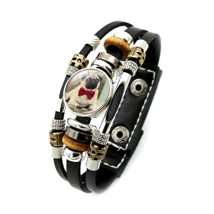 Close-up of multilayer leather bracelet with bronze beads and cute pug dog charm detail